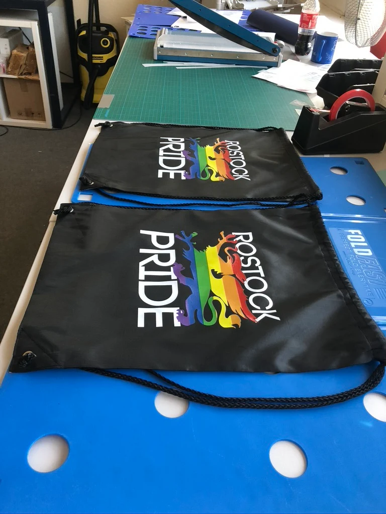 Schwarze Turnbeutel mit Rostock-Pride-Motiv auf dem Arbeitstisch